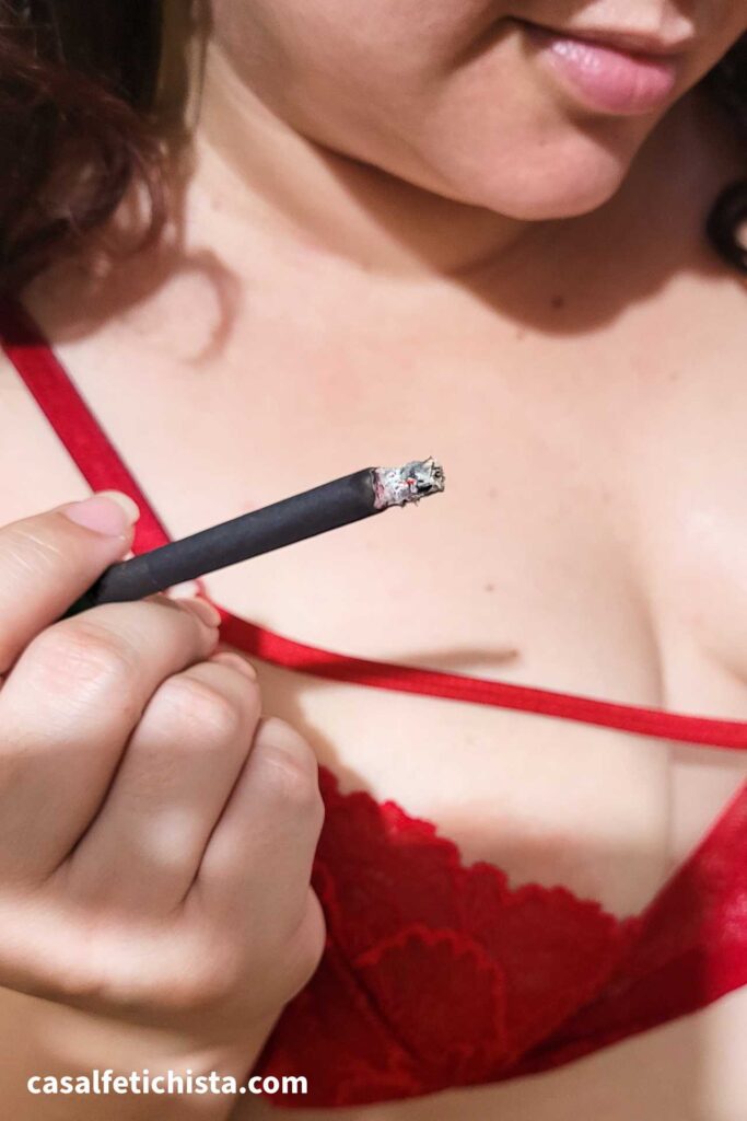 Mulher fumando cigarro preto usando lingerie vermelha